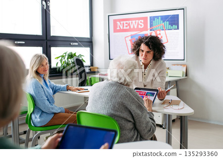 Elderly woman learning digital skills with tutor help. Elderly woman learning digital skills with tutor help. 135293360