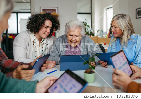Tutor teaching seniors about phone scams and digital safety. 135293370
