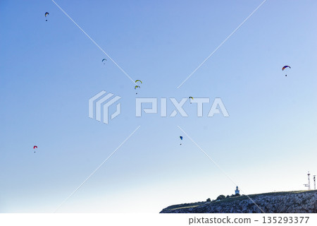 Paragliders flying in sky. Paragliders flying in sky. 135293377