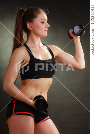 Fit woman exercising with dumbbells. Fit woman exercising with dumbbells. 135293455