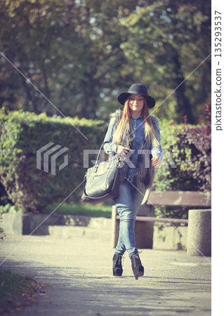 Fashionable model posing in park 135293537