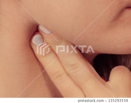 Woman checking pulse on neck closeup Woman checking pulse on neck closeup 135293539