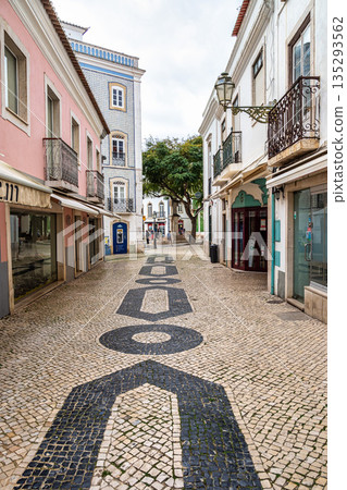 Historic part of Lagos in Portugal. Traditional colorful houses along street cobbled in geometric patterns Historic part of Lagos in Portugal. Traditional colorful houses along street cobbled in geometric patterns 135293562
