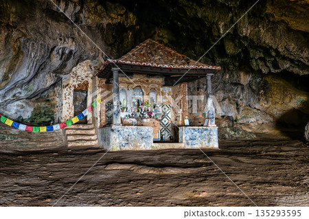 Dark interior of Lapa de Santa Margarida in Arrabida, Setubal, Portugal. Cave with small chapel of spontaneous worship Dark interior of Lapa de Santa Margarida in Arrabida, Setubal, Portugal. Cave with small chapel of spontaneous worship 135293595