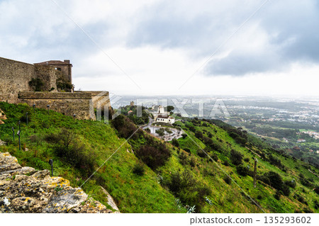 Medieval hilltop castle-fortress Castelo de Palmela in Portugal. Large walls with watchtowers. National Monument in Portugal. Medieval hilltop castle-fortress Castelo de Palmela in Portugal. Large walls with watchtowers. National Monument in Portugal. 135293602