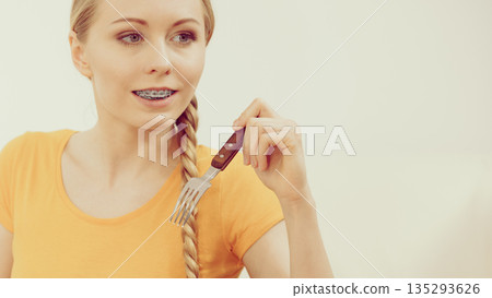 Young smiling woman holding fork Young smiling woman holding fork 135293626