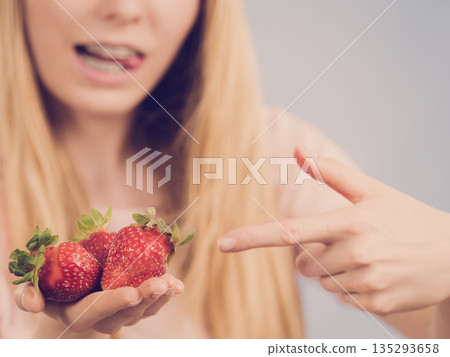 Girl showing fresh strawberries Girl showing fresh strawberries 135293658