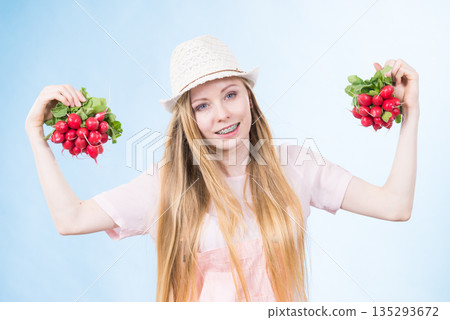 Young woman holding radish Young woman holding radish 135293672