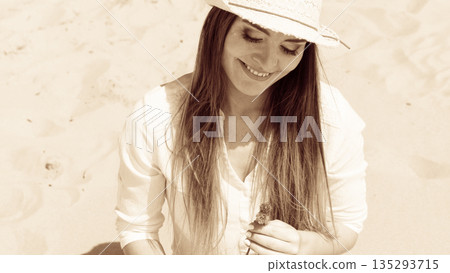 Smiling girl with flower on beach 135293715
