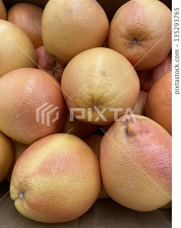 Grapefruits stacked in a box, showcasing fresh citrus fruits suitable for healthy eating background 135293765