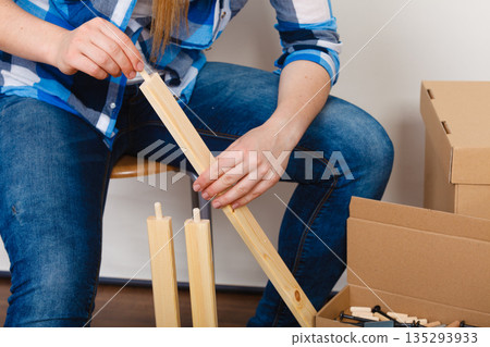 Woman assembling wood furniture. DIY. Woman assembling wood furniture. DIY. 135293933