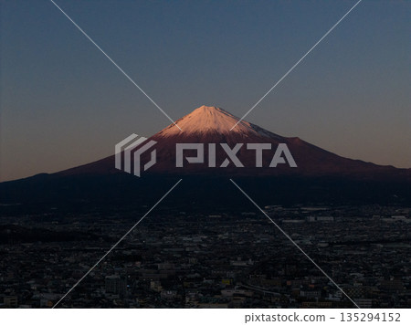 Mount Fuji and the cityscape of Fuji City at dusk as seen from the Fuji River riverbed (aerial view) Mount Fuji and the cityscape of Fuji City at dusk as seen from the Fuji River riverbed (aerial view) 135294152