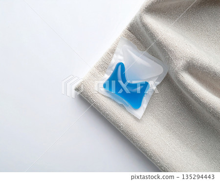 Washing pods. Soluble laundry detergent capsule on a neutral linen cloth with empty space for text. Washing pods. Soluble laundry detergent capsule on a neutral linen cloth with empty space for text. 135294443