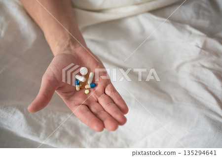 Heap of various colorful pills and capsules in hand 135294641