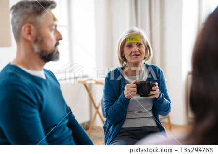 Senior woman identifying emotions during group therapy session. Senior woman identifying emotions during group therapy session. 135294768