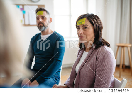 People woman identifying emotions during group therapy session. 135294769