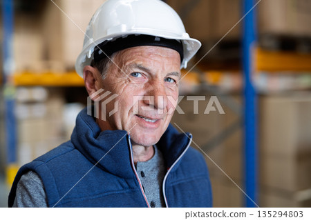 Portrait of mature warehouse worker with helmet. 135294803