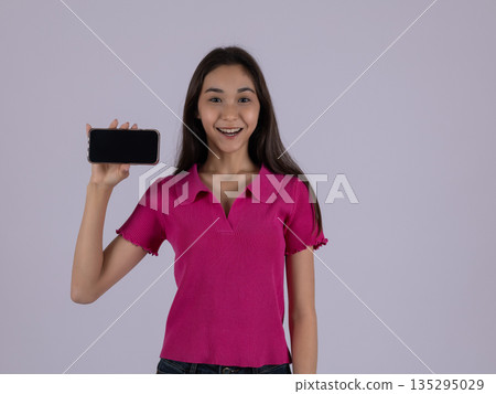 Woman showing mobile phone screen for application 135295029