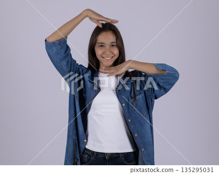Happy woman in denim shirt with hands on head 135295031
