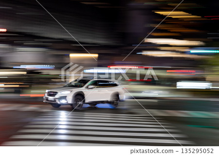 鏡頭搖攝一輛白色汽車高速駛過十字路口 鏡頭搖攝一輛白色汽車高速駛過十字路口 135295052