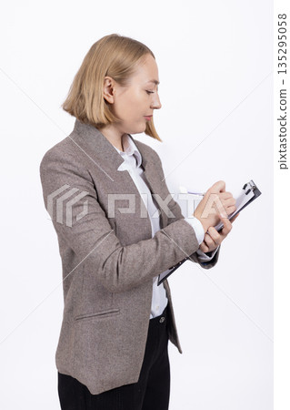 Business woman checking her watch near documents Business woman checking her watch near documents 135295058