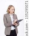 Professional woman in jacket writing on a clipboard 135295071