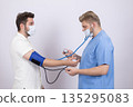 Doctor measuring blood pressure of a male patient 135295083