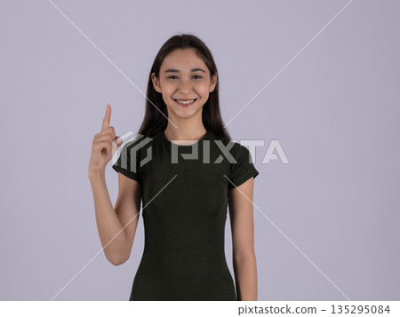 Inspired young woman pointing finger up with an idea Inspired young woman pointing finger up with an idea 135295084