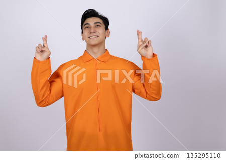 Happy man in orange jumpsuit pointing upwards 135295110
