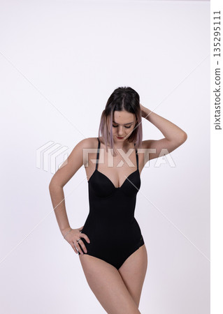 Side view of woman in black bodysuit looking away Side view of woman in black bodysuit looking away 135295111