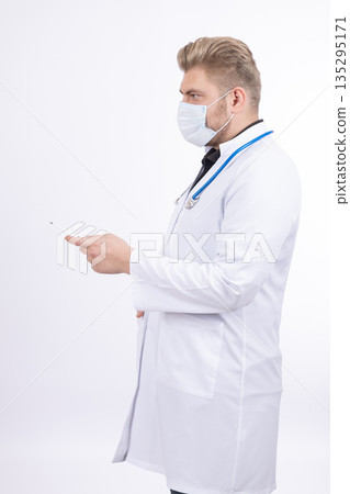 Male doctor in white coat using a smartphone 135295171