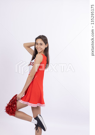 Cheerleader girl in red dress posing for the camera 135295175