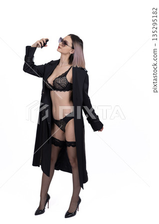 Full length woman in black coat and lingerie 135295182