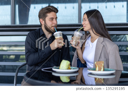 Couple drinking coffee and talking at street cafe Couple drinking coffee and talking at street cafe 135295195