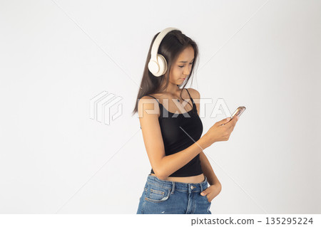 Woman with headphones using smartphone 135295224