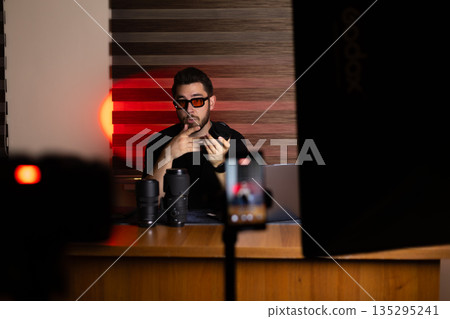 Male blogger recording video content in dark studio Male blogger recording video content in dark studio 135295241