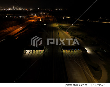 Aerial night view of highway traffic and toll plaza Aerial night view of highway traffic and toll plaza 135295250