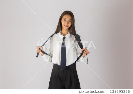 Girl student with backpack on white background 135295256
