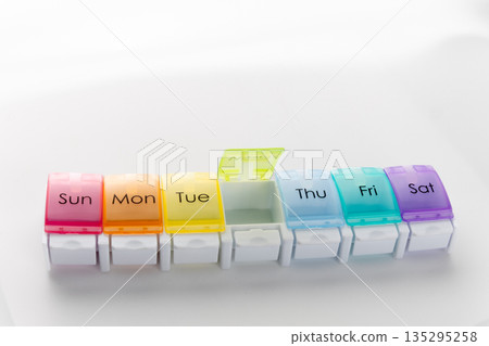 Weekly pill organizer box on white background 135295258