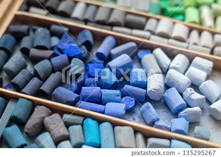 Blue gray soft pastels crayons collection in wooden case. Painter's multicolor background. Chalk pieces top view 135295267