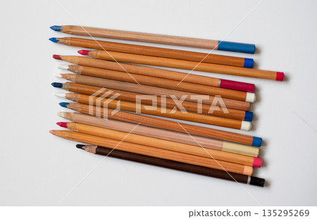 Soft pastel pencils isolated on white, top view. Multicolored pencils. Art supplies for drawing and graphics. Soft pastel pencils isolated on white, top view. Multicolored pencils. Art supplies for drawing and graphics. 135295269
