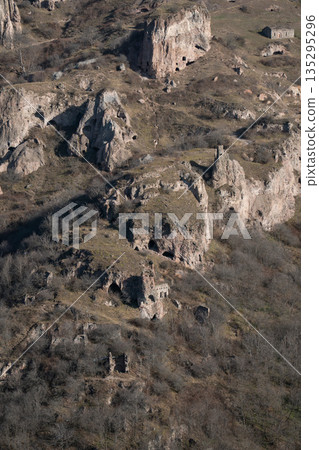 Stone houses, cave structures of Khndzoresk, Armenia, set on rocky hillside with dry vegetation, earthy tones, and a quiet rural atmosphere Stone houses, cave structures of Khndzoresk, Armenia, set on rocky hillside with dry vegetation, earthy tones, and a quiet rural atmosphere 135295296