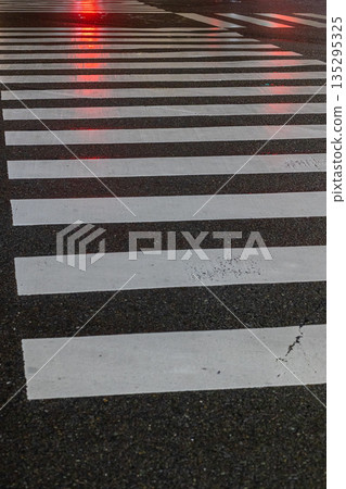 Crosswalk with light reflecting on wet road surface_Vertical Crosswalk with light reflecting on wet road surface_Vertical 135295325