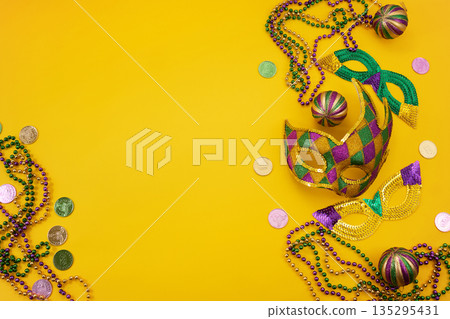 Mardi gras carnival masks beads coins yellow background Mardi gras carnival masks beads coins yellow background 135295431
