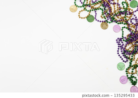 Mardi gras beads and doubloons on white background Mardi gras beads and doubloons on white background 135295433
