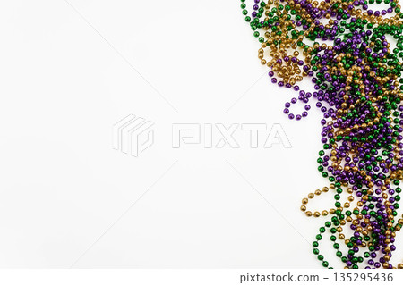 Mardi gras beads creating festive border on white background 135295436