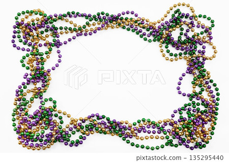 Mardi gras beads forming an oval frame on white background Mardi gras beads forming an oval frame on white background 135295440
