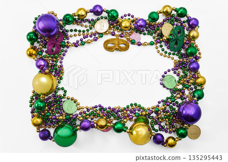 Mardi gras frame with colorful beads and venetian masks Mardi gras frame with colorful beads and venetian masks 135295443