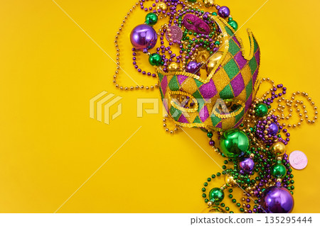 Mardi gras mask and beads on yellow background 135295444
