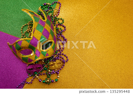 Mardi gras carnival mask and beads on glitter background 135295448